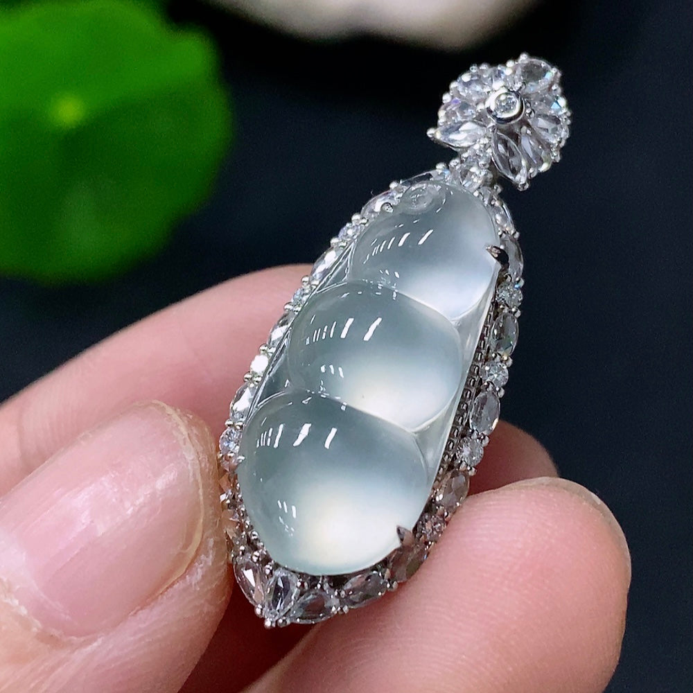 Jadeite blessed bean pendant set in 18k gold with diamond accents, featuring a polished jade pendant and matching chain.
