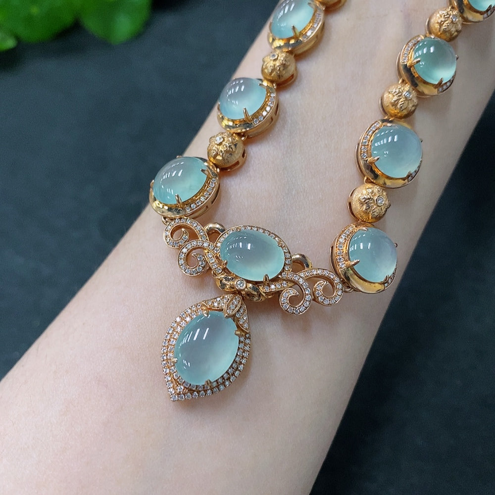 Jadeite cabochon necklace with 18K gold and diamond accents, featuring a large green jade stone and intricate gold detailing.