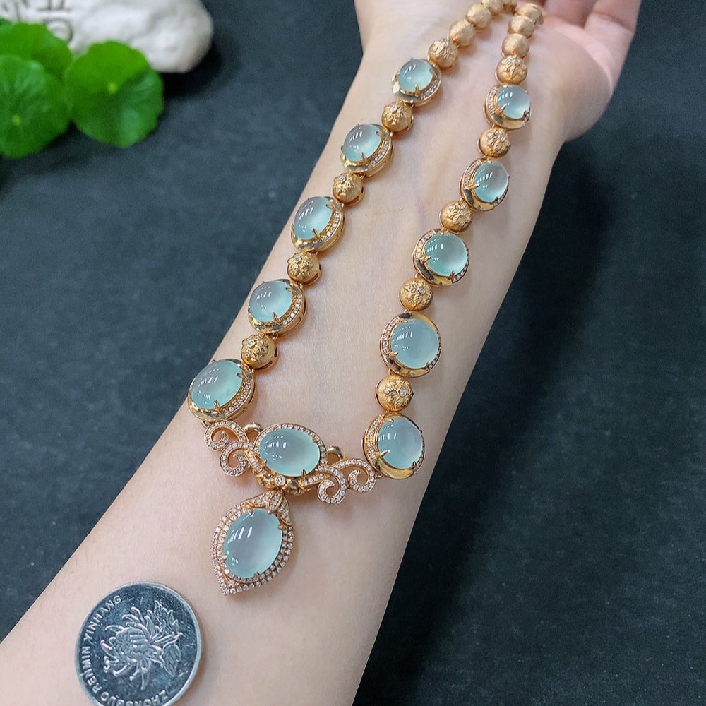 Jadeite cabochon necklace with 18K gold and diamond accents, featuring polished jade stones and elegant gold setting.