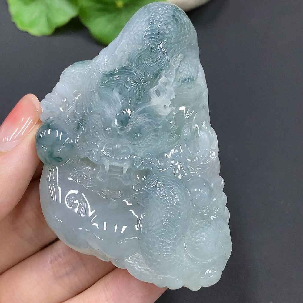 Jadeite dragon soaring the world pendant in green jade, crafted by HUILIU HQ, weighing 90.993 grams, detailed and polished.