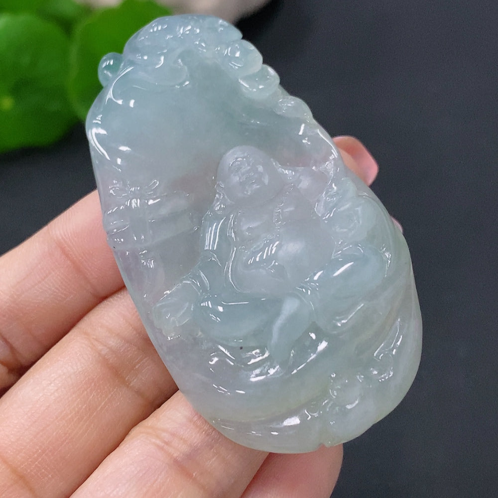 Jadeite Buddha pendant in green jade, featuring intricate carved details, hanging on a silk cord.