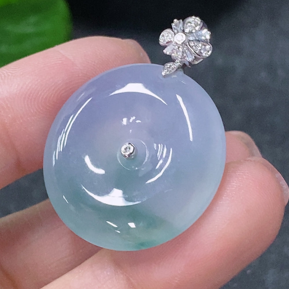 Jadeite pendant with peace knot design in 18k gold with diamond accents, weighing approximately 7g.