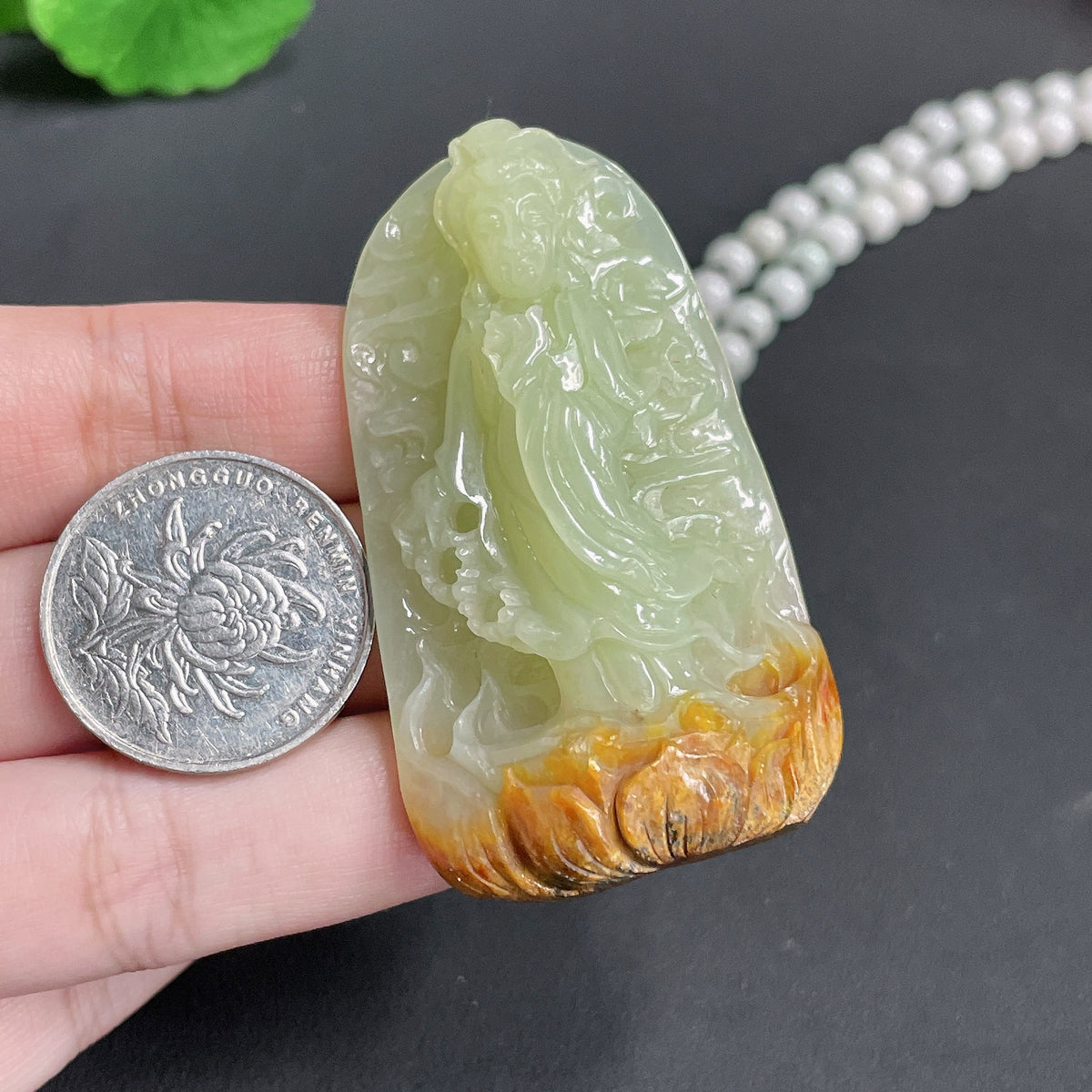 Huiliu-certified Khotan jade Guanyin pendant with chain, featuring smooth, polished jade and detailed carved figure on a neutral background.