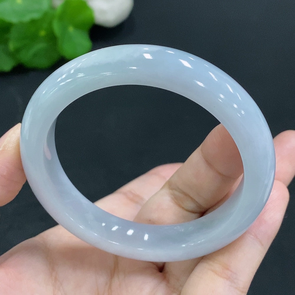 Huiliu Certified HKHQ jadeite round bangle with smooth, polished surface, showcasing vibrant green jade in a close-up view.