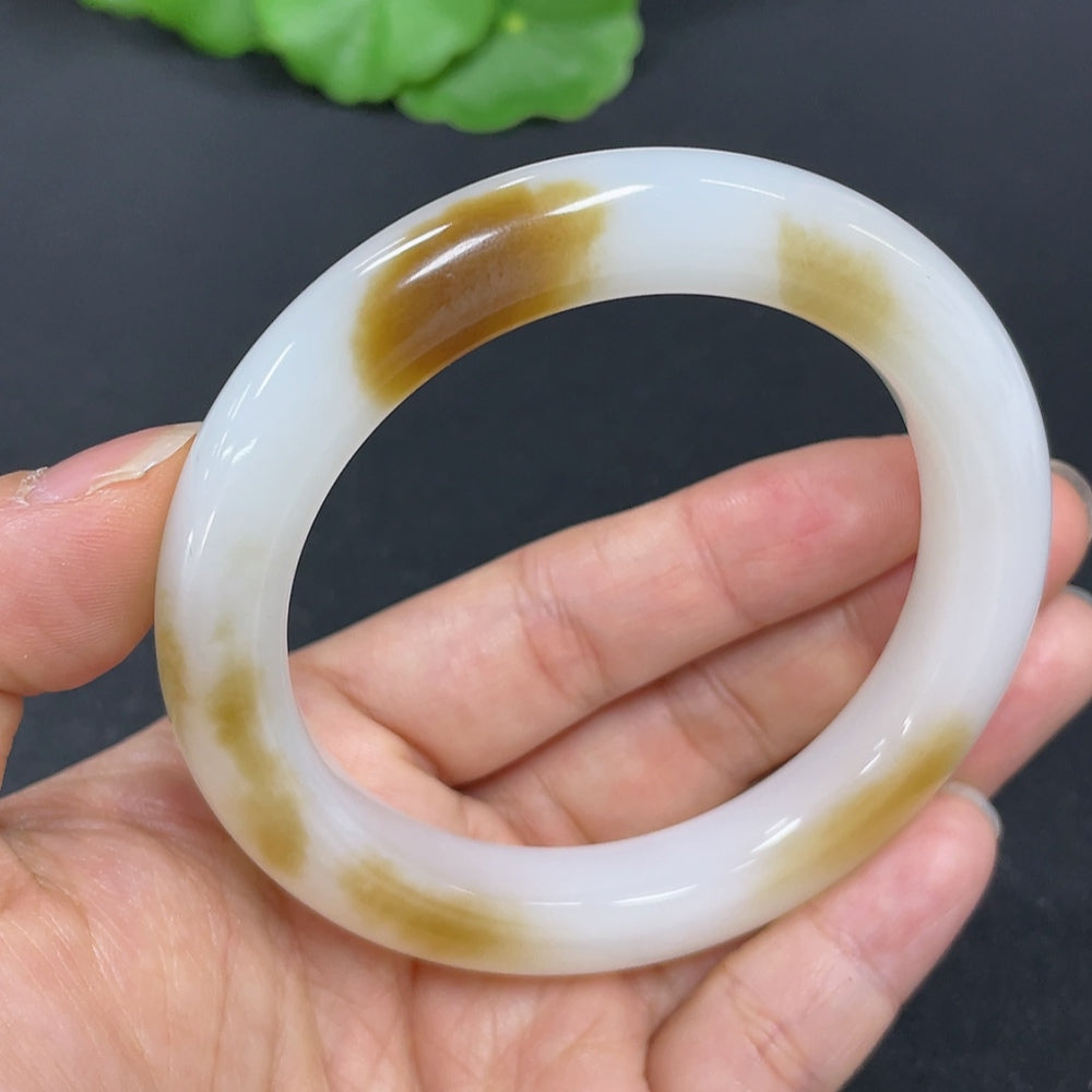 HKHQ Hetian Jade round bracelet, size 55.9, weighing 52.5g, showcasing smooth jade beads on a natural skin tone background.