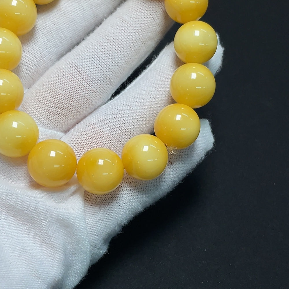 Amber beeswax bracelet by HKHQ featuring 13.9mm amber beads, total weight approximately 23.61g, displayed on a neutral background.