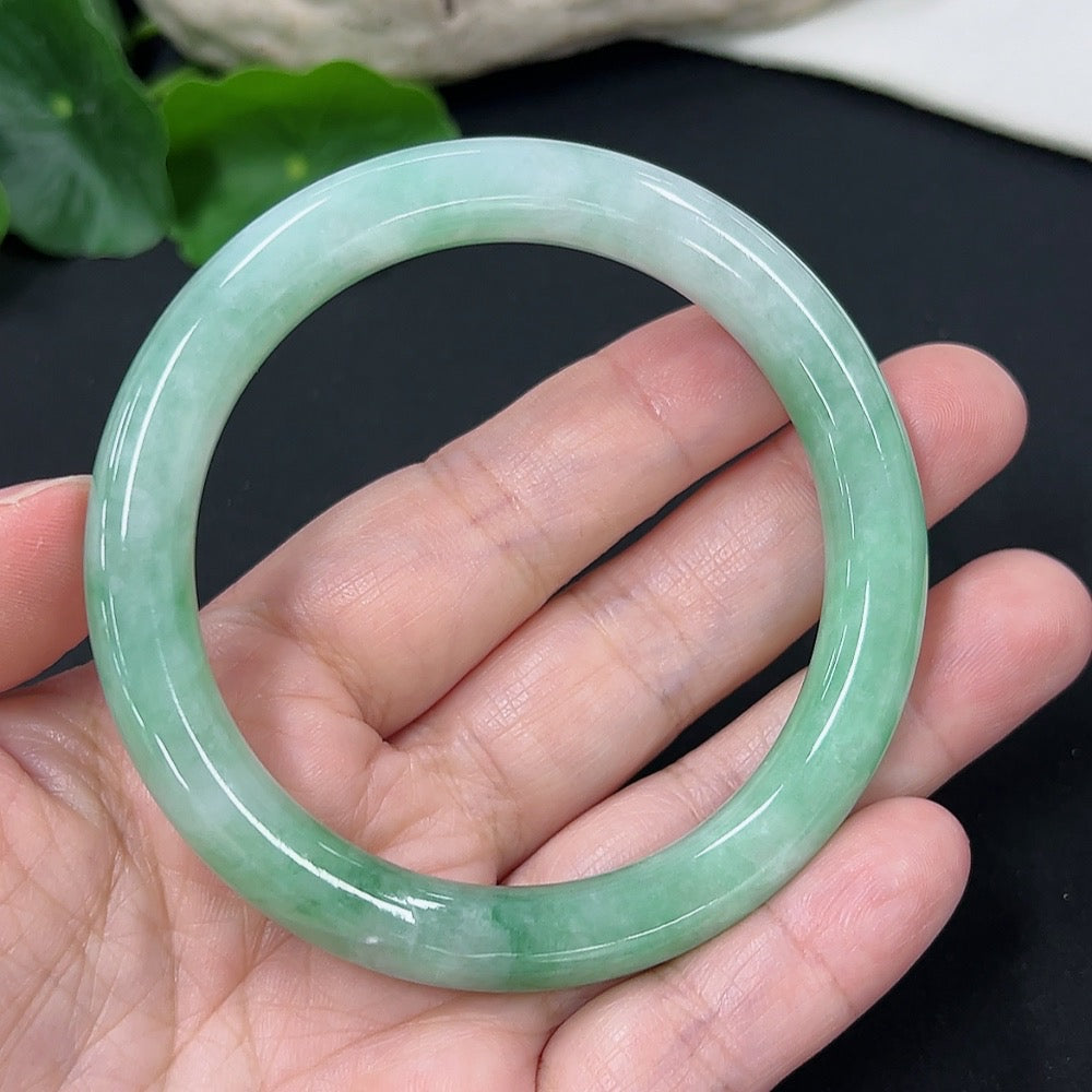 HKHQ Jadeite round bangle in size 56, polished jadeite bracelet weighing approximately 43 grams, showcasing smooth, glossy surface.