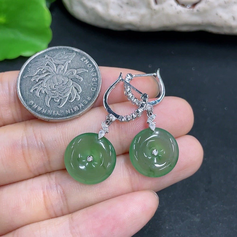 HKHQ jadeite peace knot earrings with inlaid design and 18k gold, shown resting on a white background.