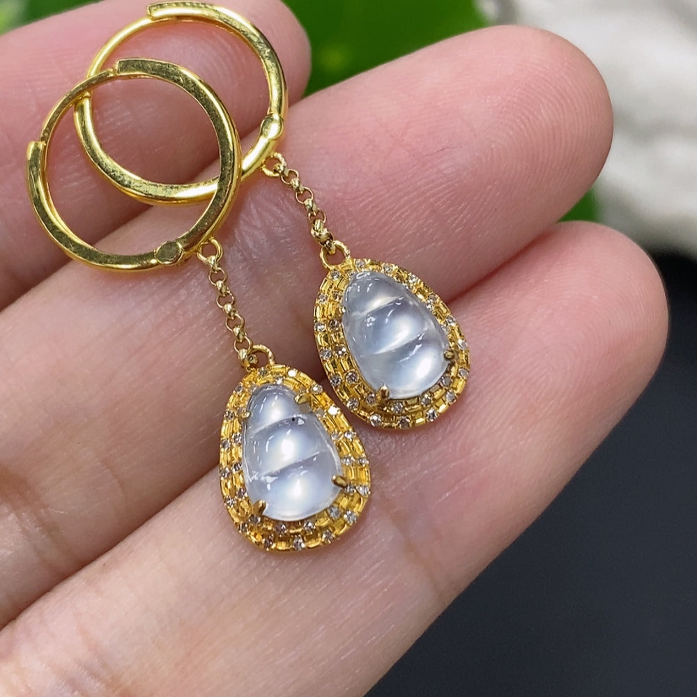 Jadeite auspicious bean earrings set in 18K gold with diamond accents, featuring smooth green jade beans on gold hooks.