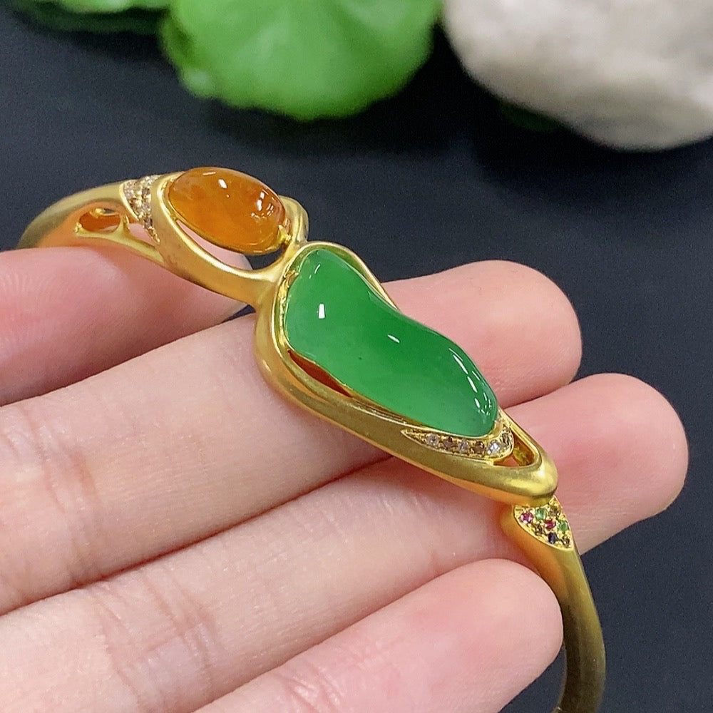 Jadeite inlaid bangle with diamond accents, 18k gold, HKHQ, showcasing intricate jade and diamond detailing on a gold bracelet.