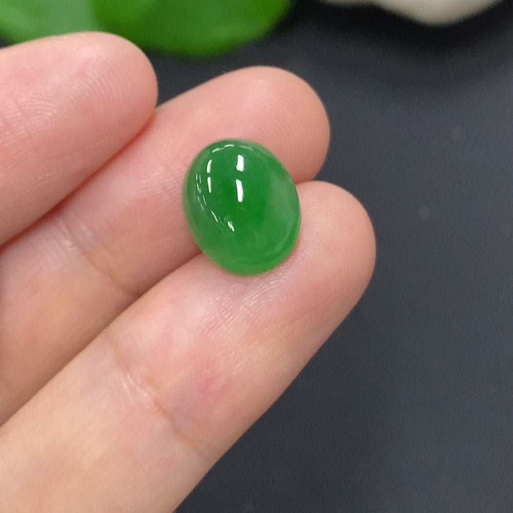 Small jadeite cabochon jewelry piece from HKHQ, weighing approximately 1.1g, featuring smooth polished green stone.