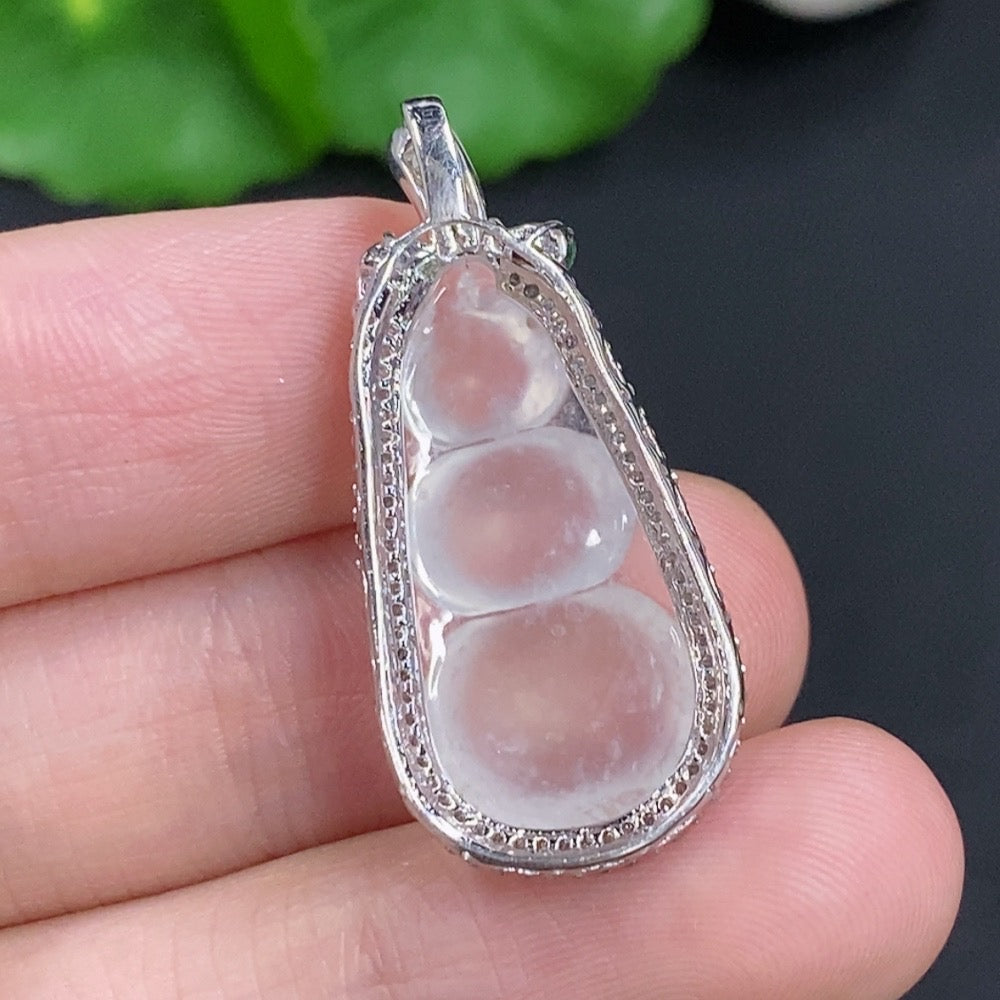 Jadeite lucky bean pendant with 18K gold accents and diamond details, showcasing smooth green jade in a jewelry setting.