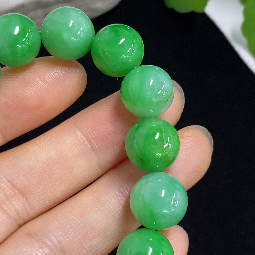 Jadeite bracelet with 11mm beads, HKHQ brand, showcasing smooth green jade stones on a white background.
