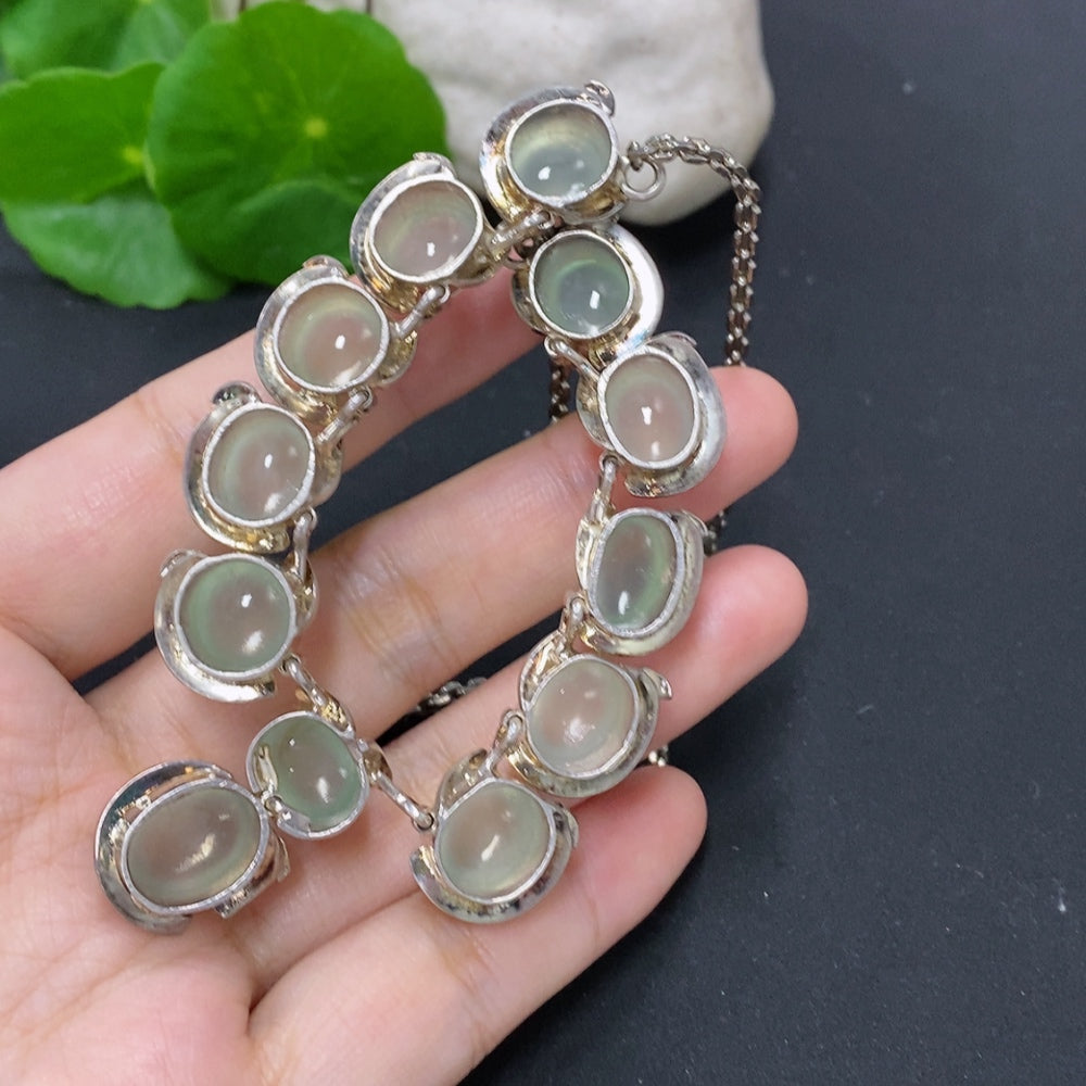 Jadeite cabochon gemstone with non-gold setting, weighing approximately 61.2 grams, displayed on a neutral background.
