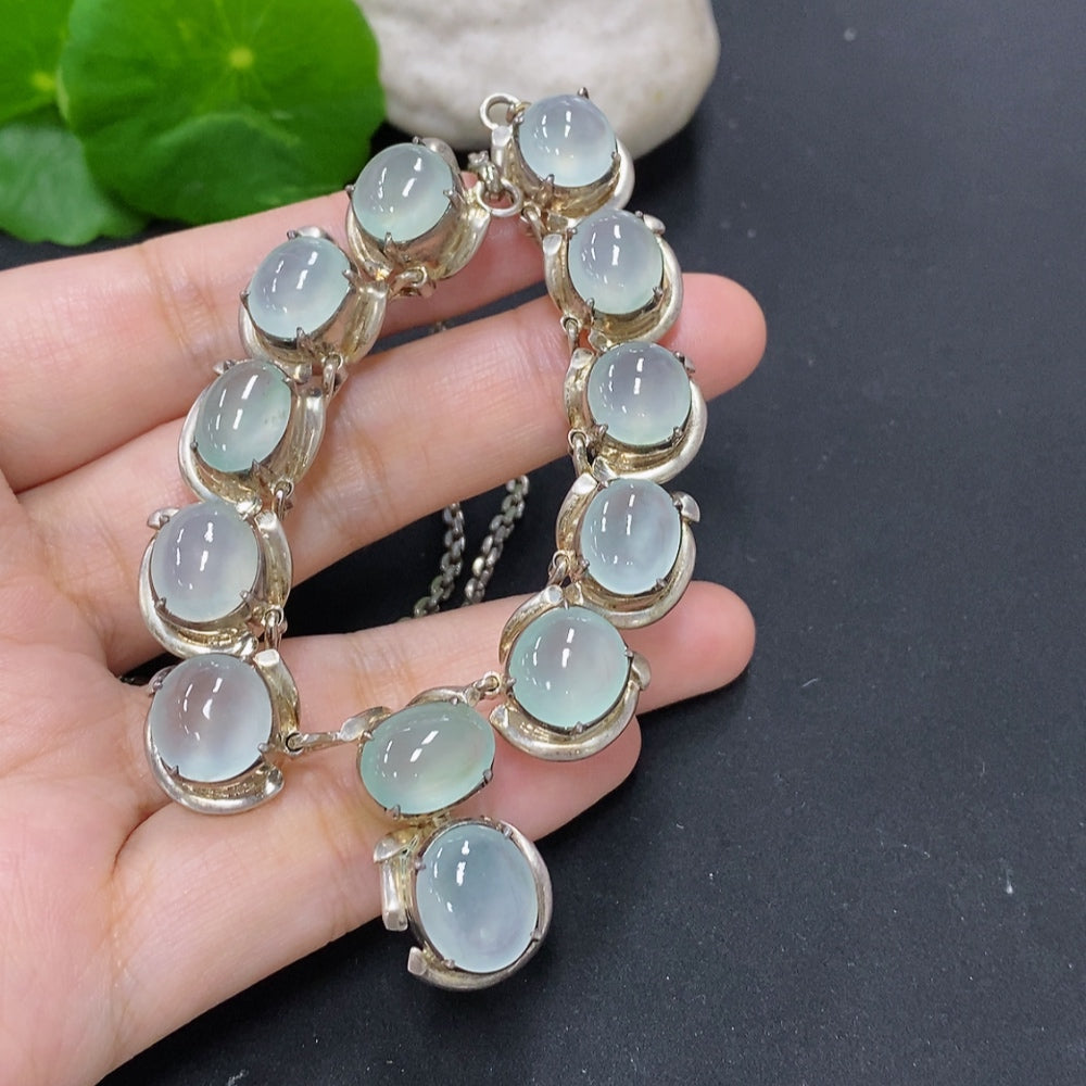 Jadeite cabochon gemstone from HKHQ in a non-gold setting, weighing approximately 61.2 grams, showcasing smooth polished surface.