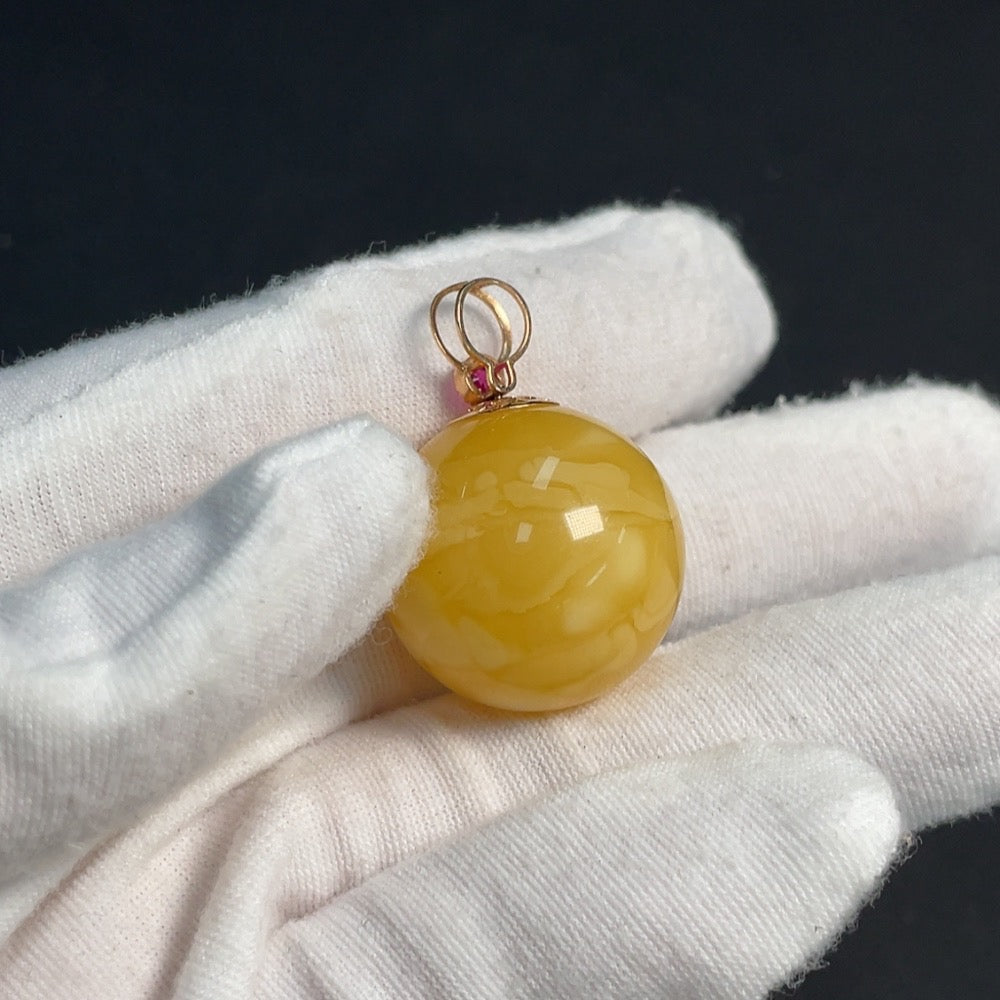Amber beeswax pendant with 18K gold setting featuring gemstone details, crafted by HKHQ.