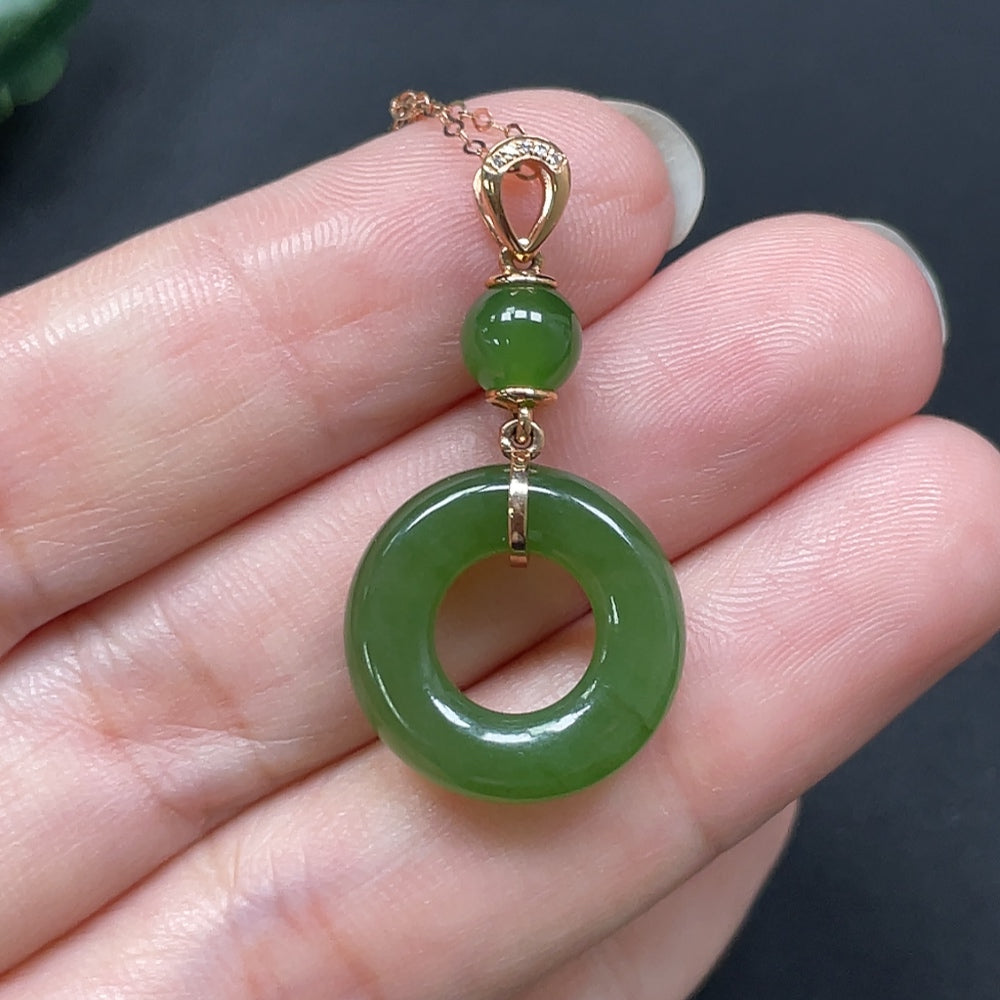 Hetian jade peace knot pendant with 18K gold accents and diamond details, showcasing intricate craftsmanship and elegant design.