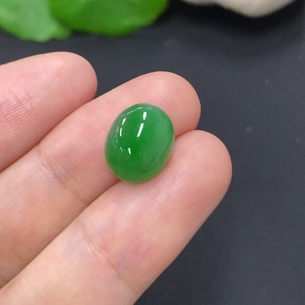 Jadeite cabochon jewelry by HKHQ showing a smooth, polished green gemstone with a rounded shape and glossy surface.