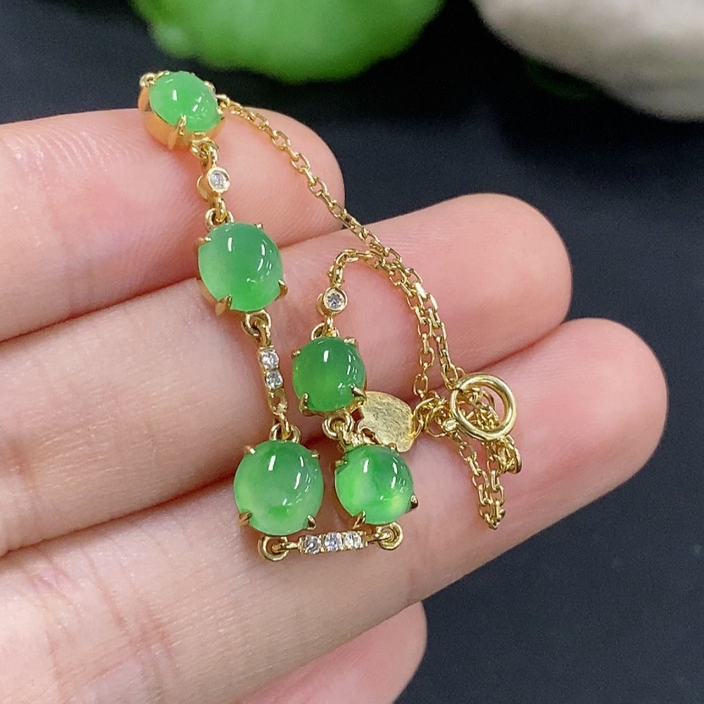 Jadeite cabochon bracelet with 18k gold and diamond accents, HKHQ, featuring smooth green jade stones and elegant gold settings.