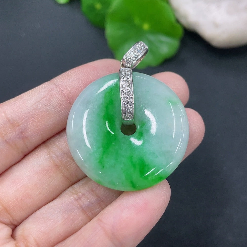 Jadeite pendant with peace knot design, 18k gold accents, diamond details, featuring a smooth jade stone on a jewelry chain.