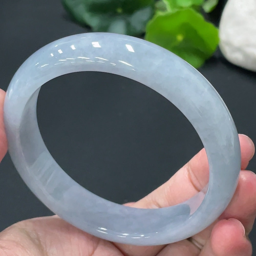 Huiliu Certified HKHQ jadeite round bangle showcasing smooth, polished green jade with natural variations and a glossy finish.