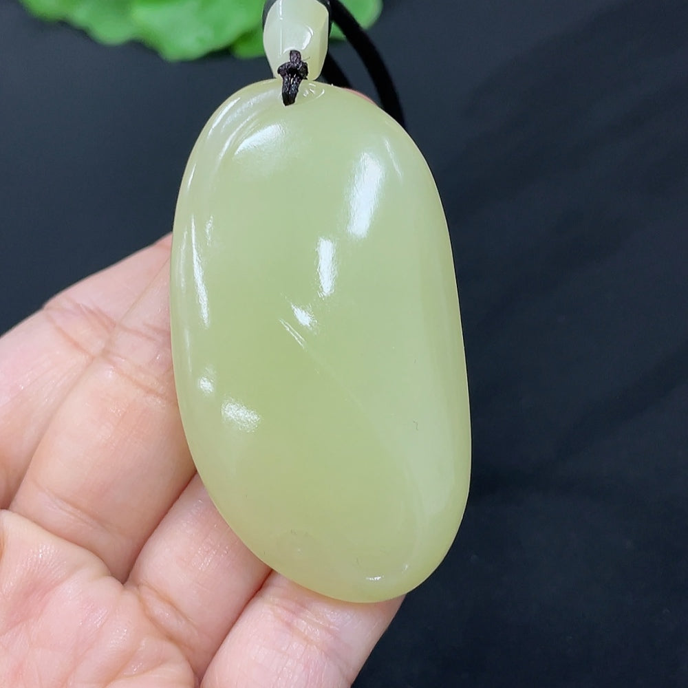 Hetian jade freeform pendant necklace with smooth, polished jade stone featuring natural curves and a sleek design.