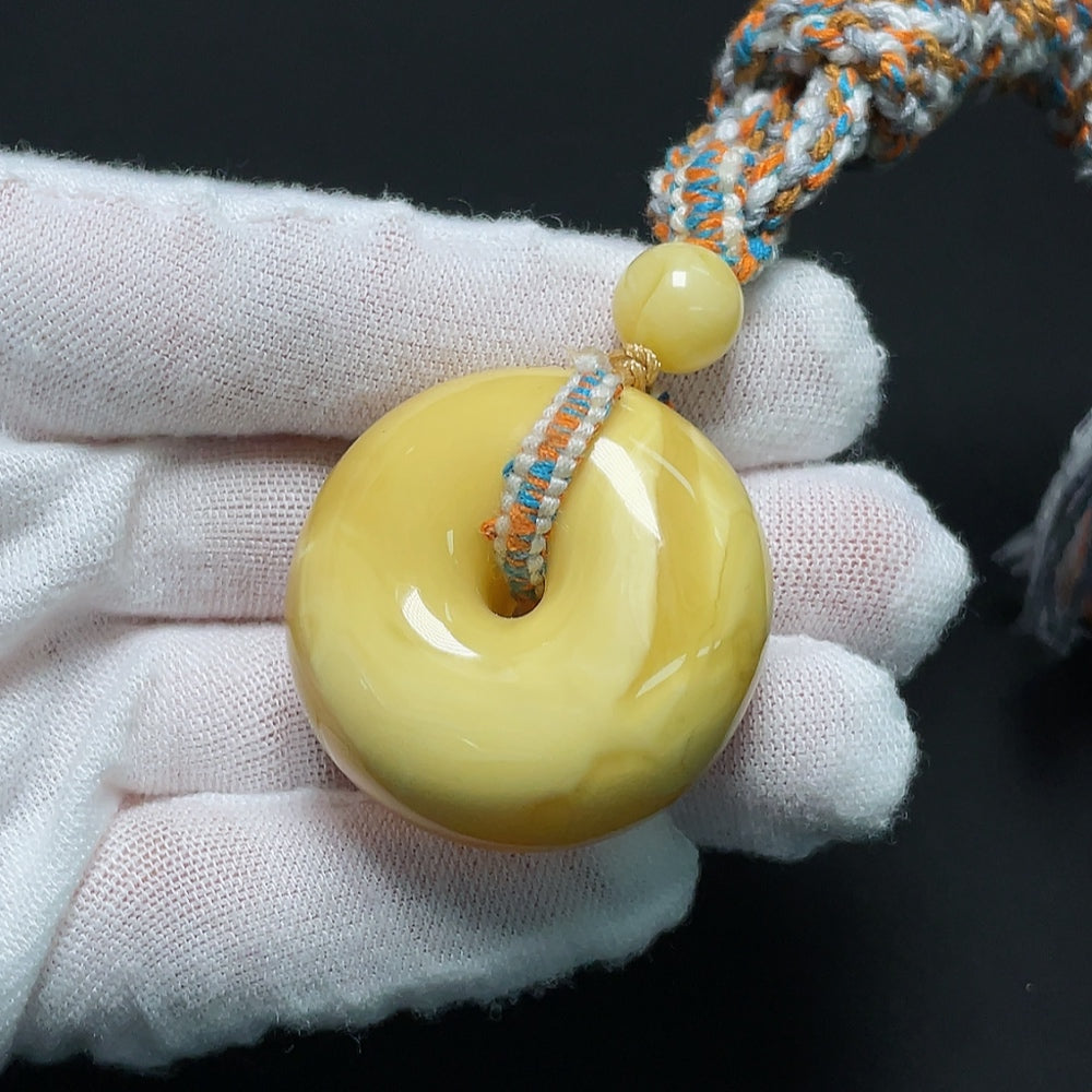 Amber beeswax pendant with natural amber color and cord, weighing approximately 20.21g, by HKHQ.