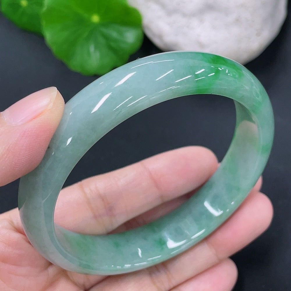 Jadeite round bangle with size 55.7mm and weight 43.49g, crafted from green jade, showcasing smooth, polished surface and rounded shape.