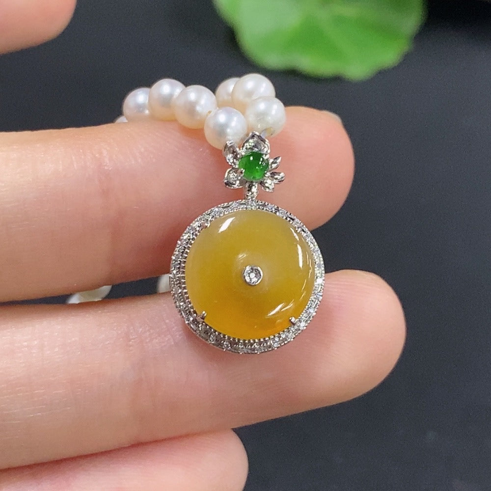 Jadeite auspicious pendant with diamond accents, paired with pearls, set in 18k metal, showcasing intricate inlay and natural color.
