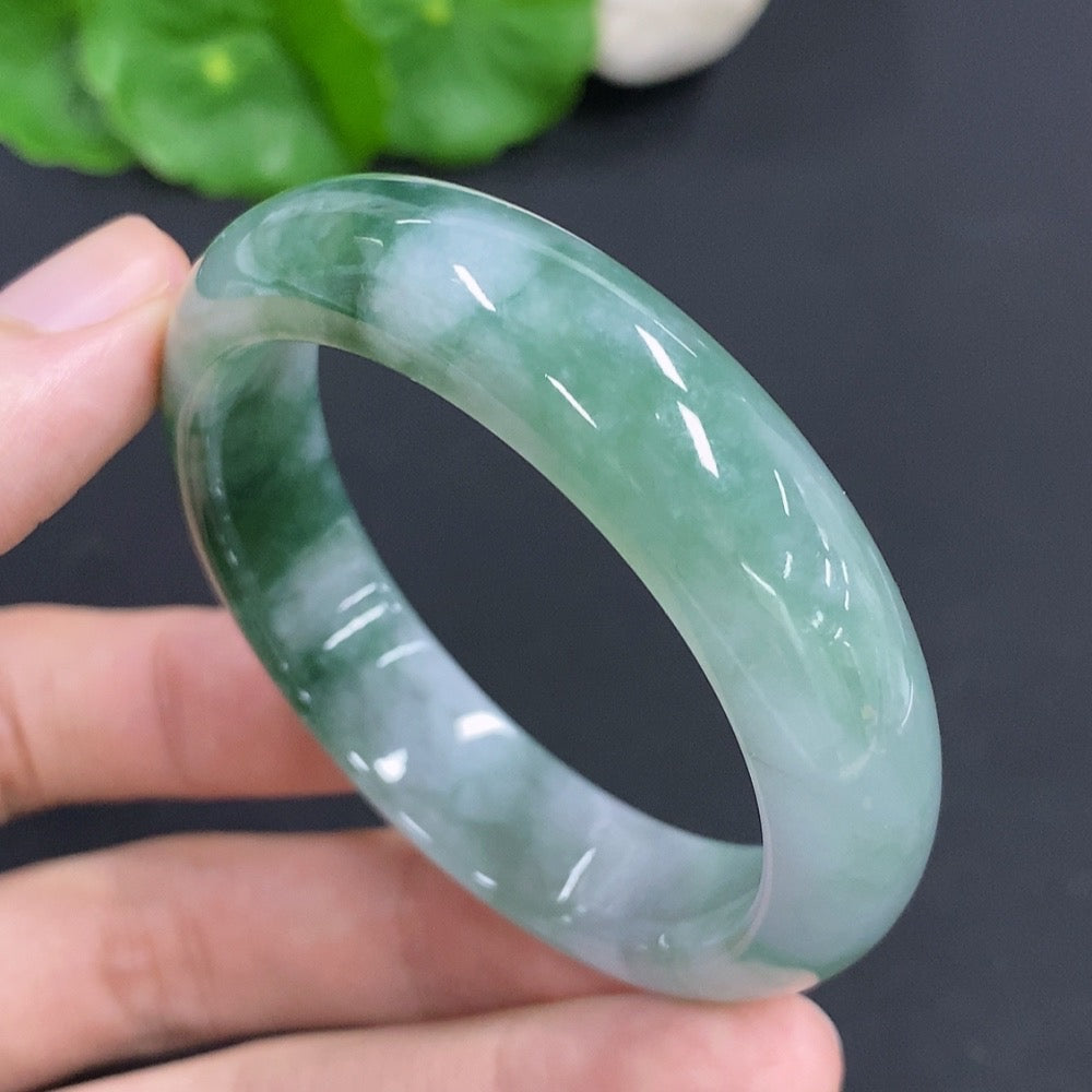 HKHQ Jadeite oval bangle in size 53, featuring a smooth, polished surface and weighing 38.1 grams, displayed on a neutral background.