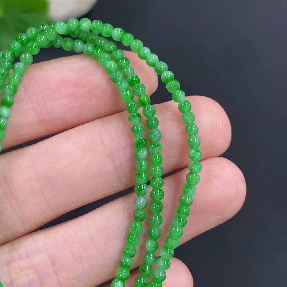 Jadeite bead necklace by HKHQ featuring smooth, green jade beads, weighs 7.7g, displayed on a neutral background.