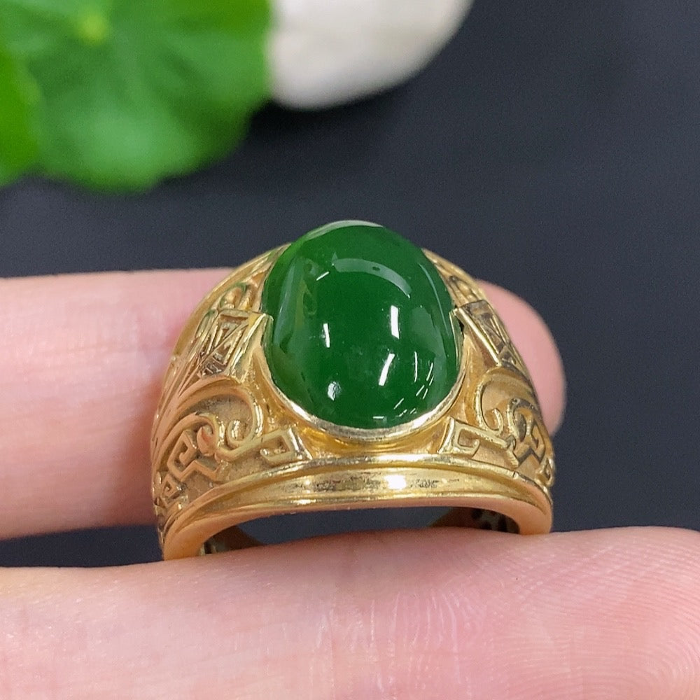 Jadeite cabochon ring set in 18K gold with a smooth, polished surface and gold band, featuring a vibrant green jade stone.