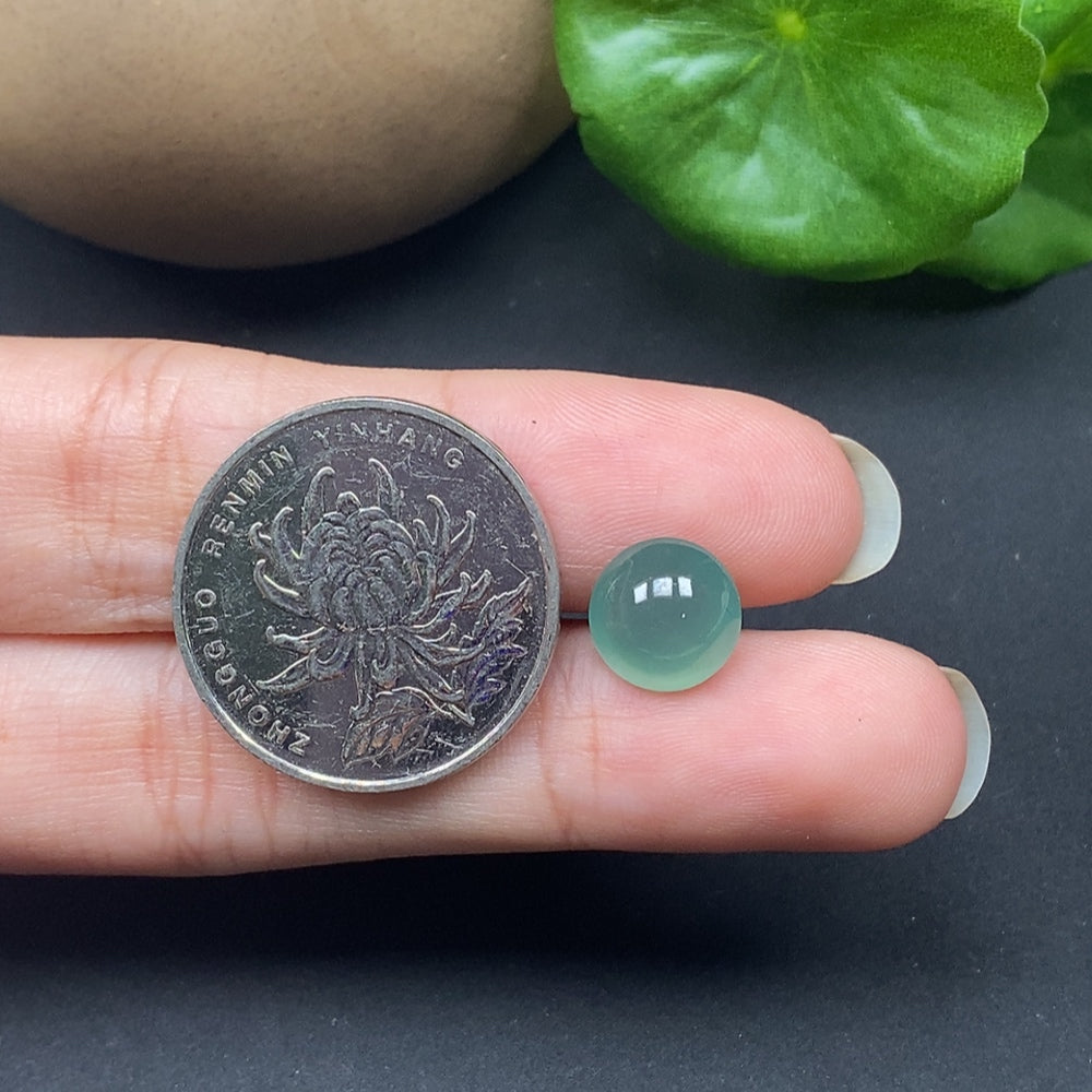 Close-up of HKHQ jadeite cabochon inlay, approximately 0.75g, showcasing smooth, polished green jade stone with detailed craftsmanship.