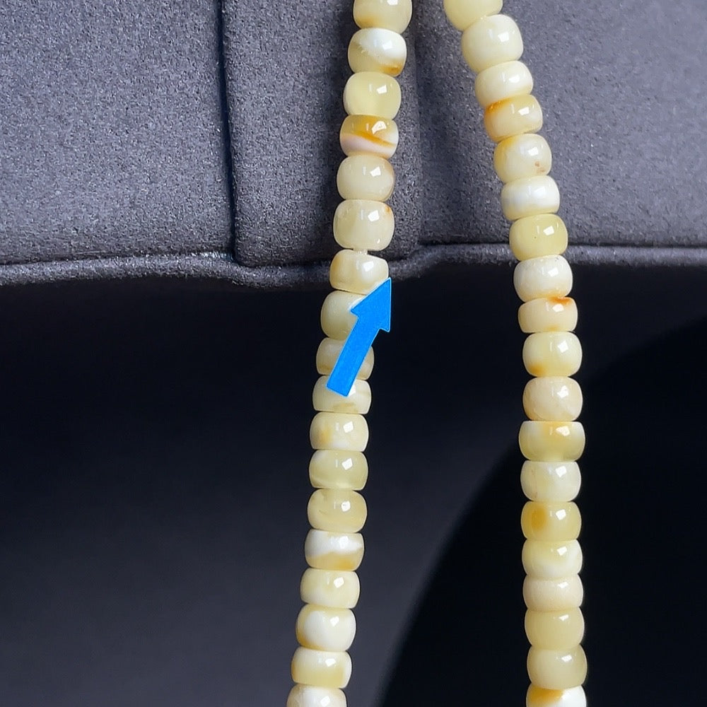 Amber Beeswax Pendant by HKHQ with colorless coating, partial repairs visible, attached to cord, includes collection certificate.