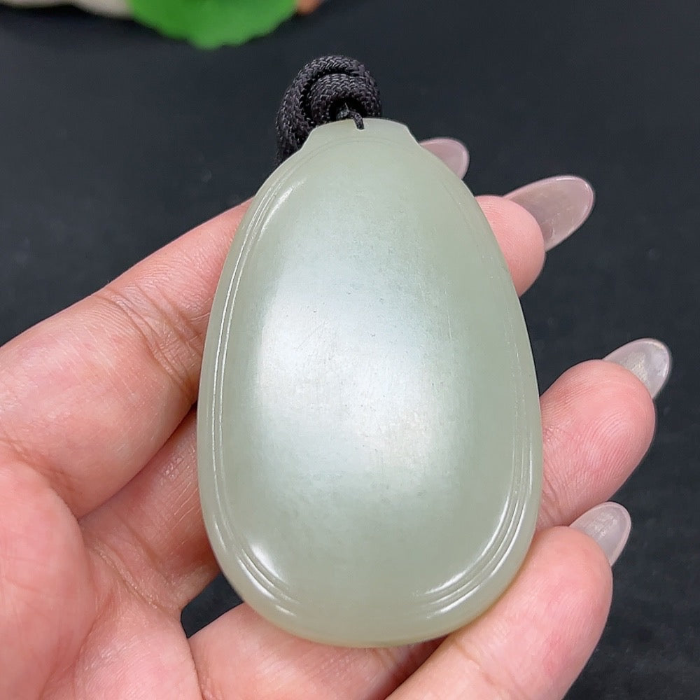 Hetian jade plain pendant from HKHQ featuring a smooth, polished jade piece with a rope, weighing approximately 55.6g.
