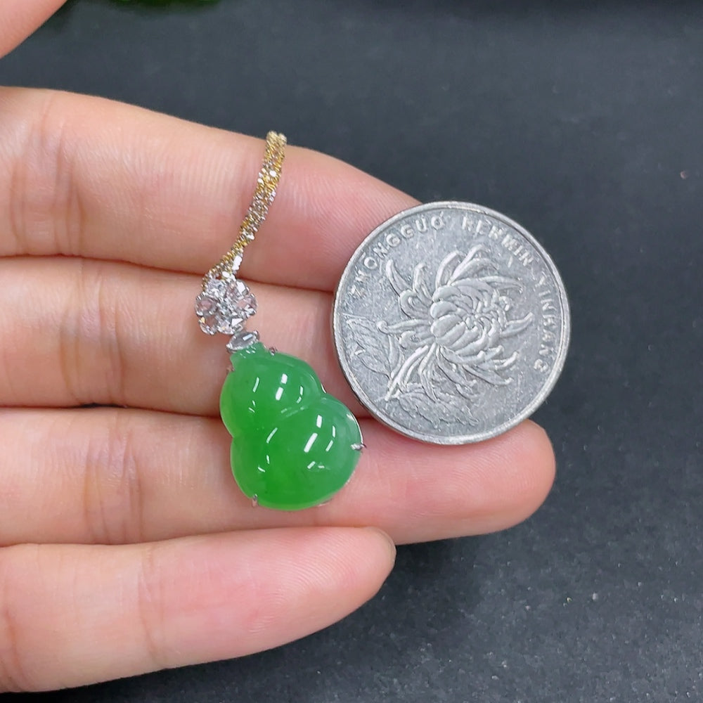 Jadeite gourd pendant with 18k gold and diamonds, featuring intricate inlay, displayed with chain on a plain background.