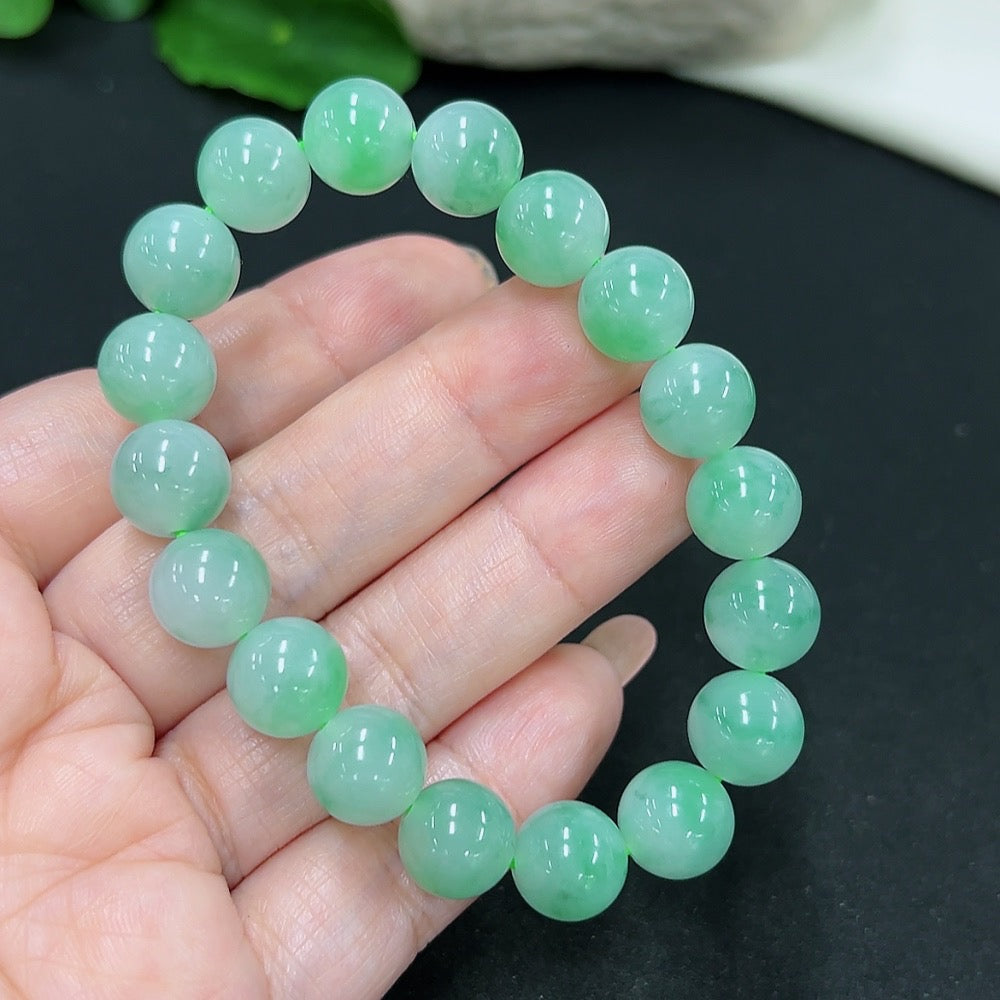 Elegant jadeite bracelet from HKHQ featuring smooth, polished green jade beads on a stretchy cord.