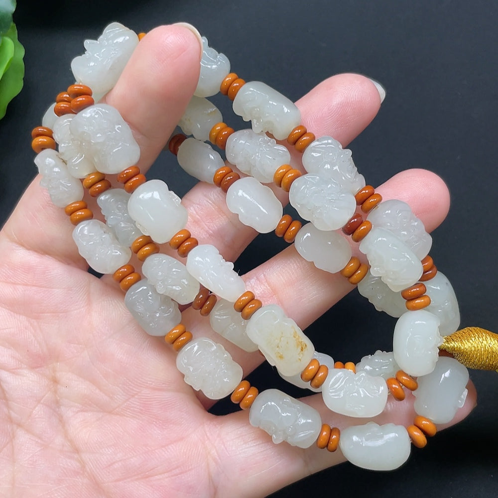 Hetian Jade Eighteen Arhats bracelet with beaded string, weighs approx. 65.71g, featuring colorful beads and detailed Arhats design.
