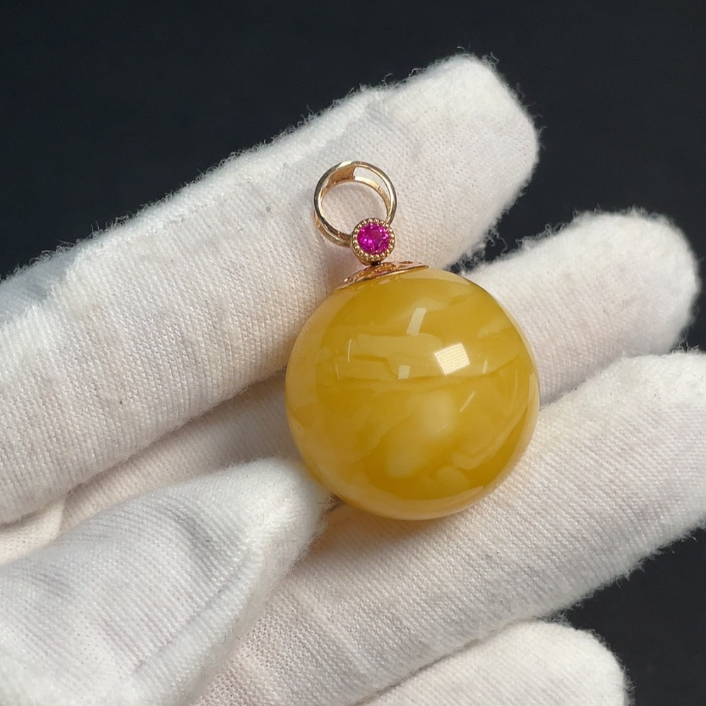 Amber beeswax pendant with 18K gold setting, featuring natural gemstone details and intricate craftsmanship.