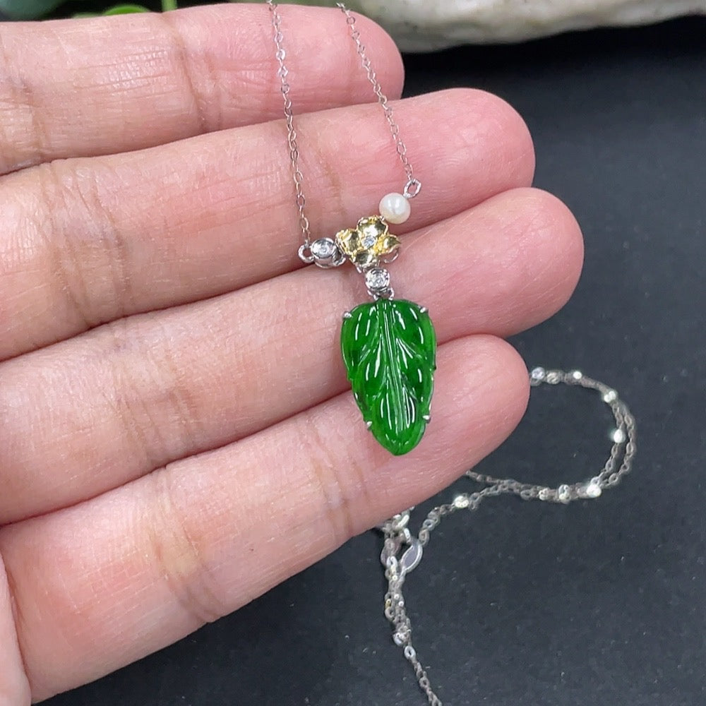 Jadeite leaf pendant with 18K gold accents and diamond details, shown with chain, weighing approximately 1.45g.