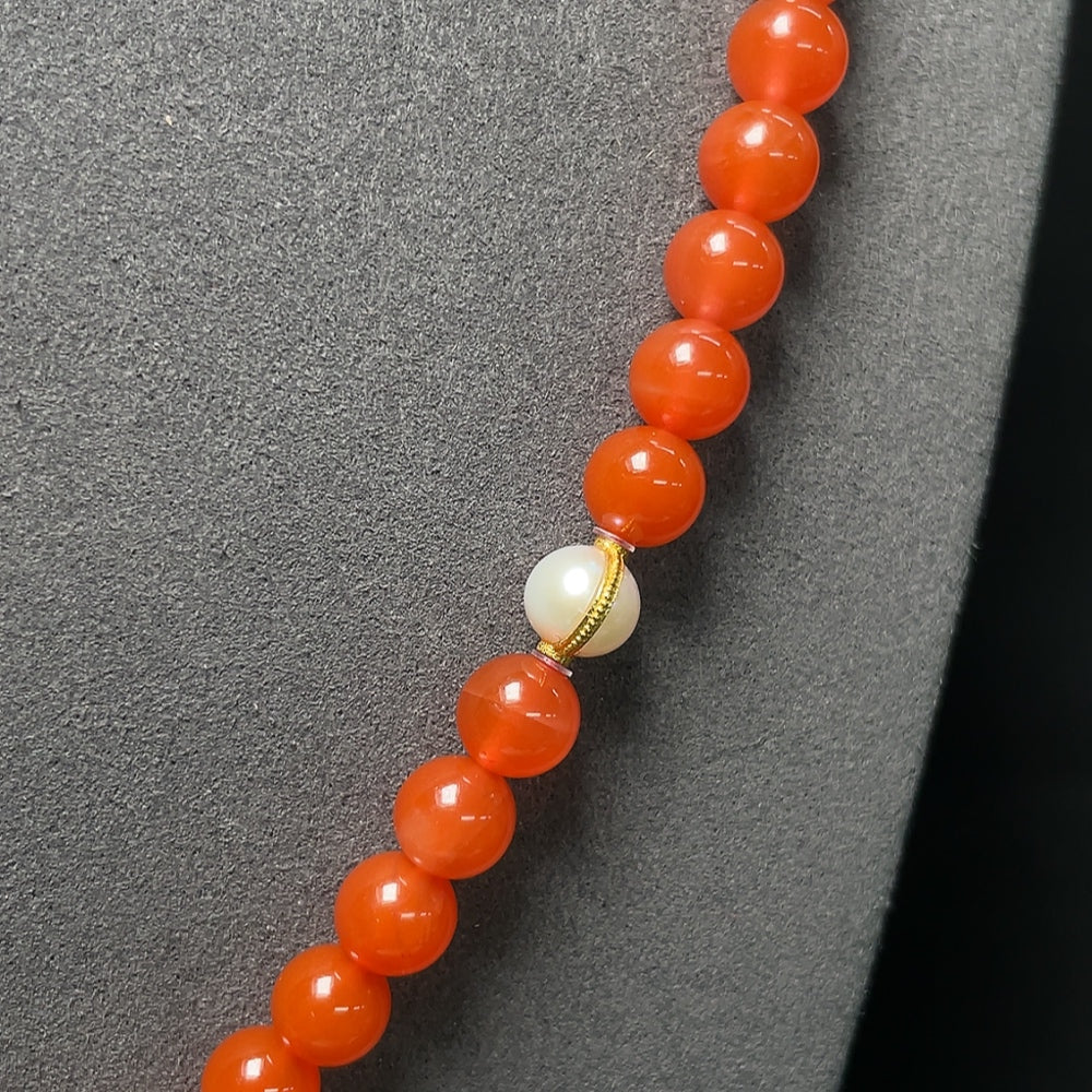 Red agate bead strand necklace featuring tourmaline, pearls, and 18K gold accents, showcasing elegant jewelry with vibrant gemstones.