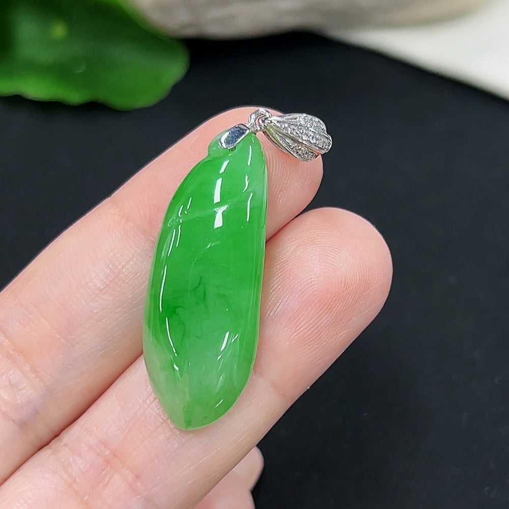 Jadeite melon pendant with diamond accents, set in 18K gold, shown on a jewelry display with a sleek, polished finish.