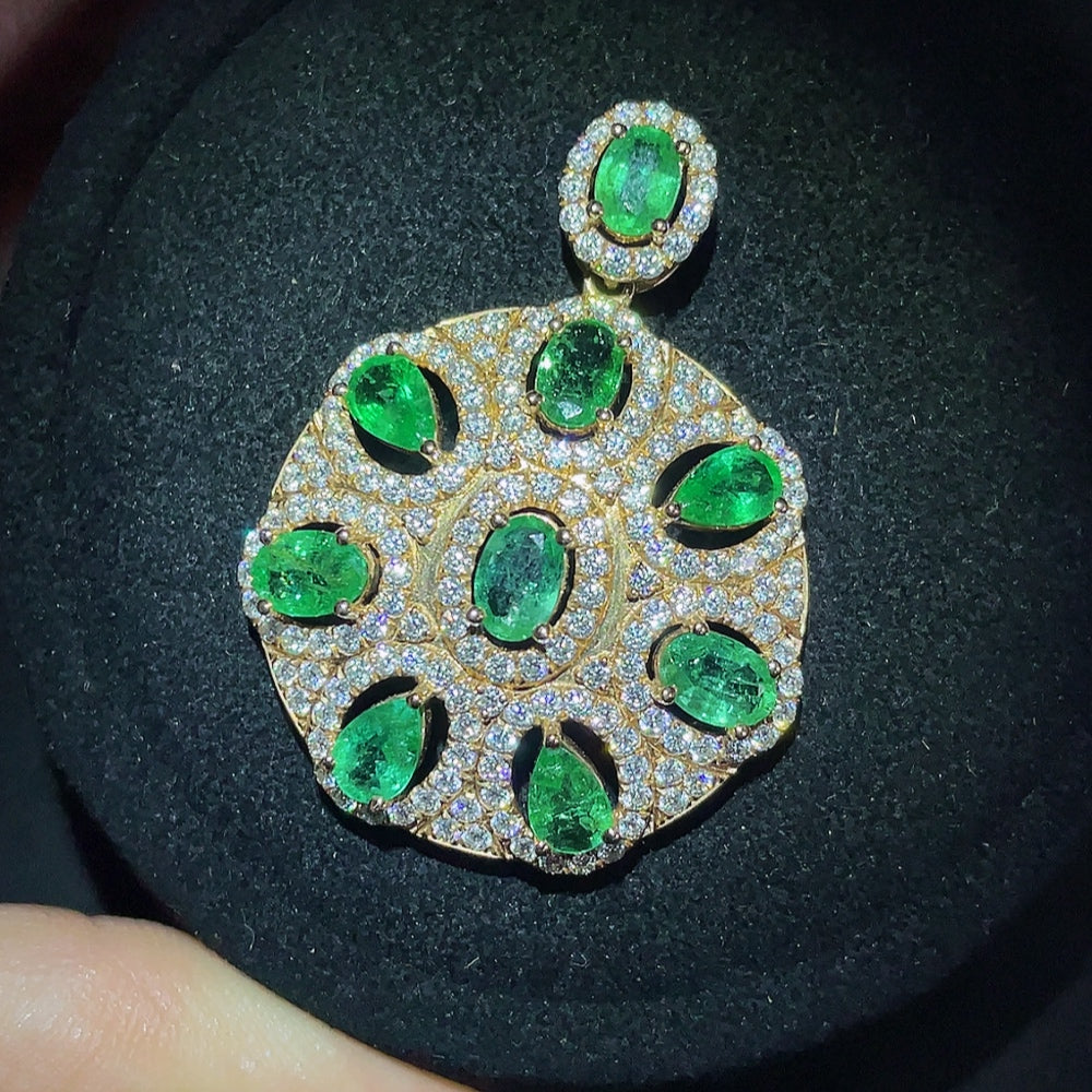Emerald pendant necklace with 18K gold setting, clarity enhanced, by HKHQ, showcasing a vibrant green gemstone.