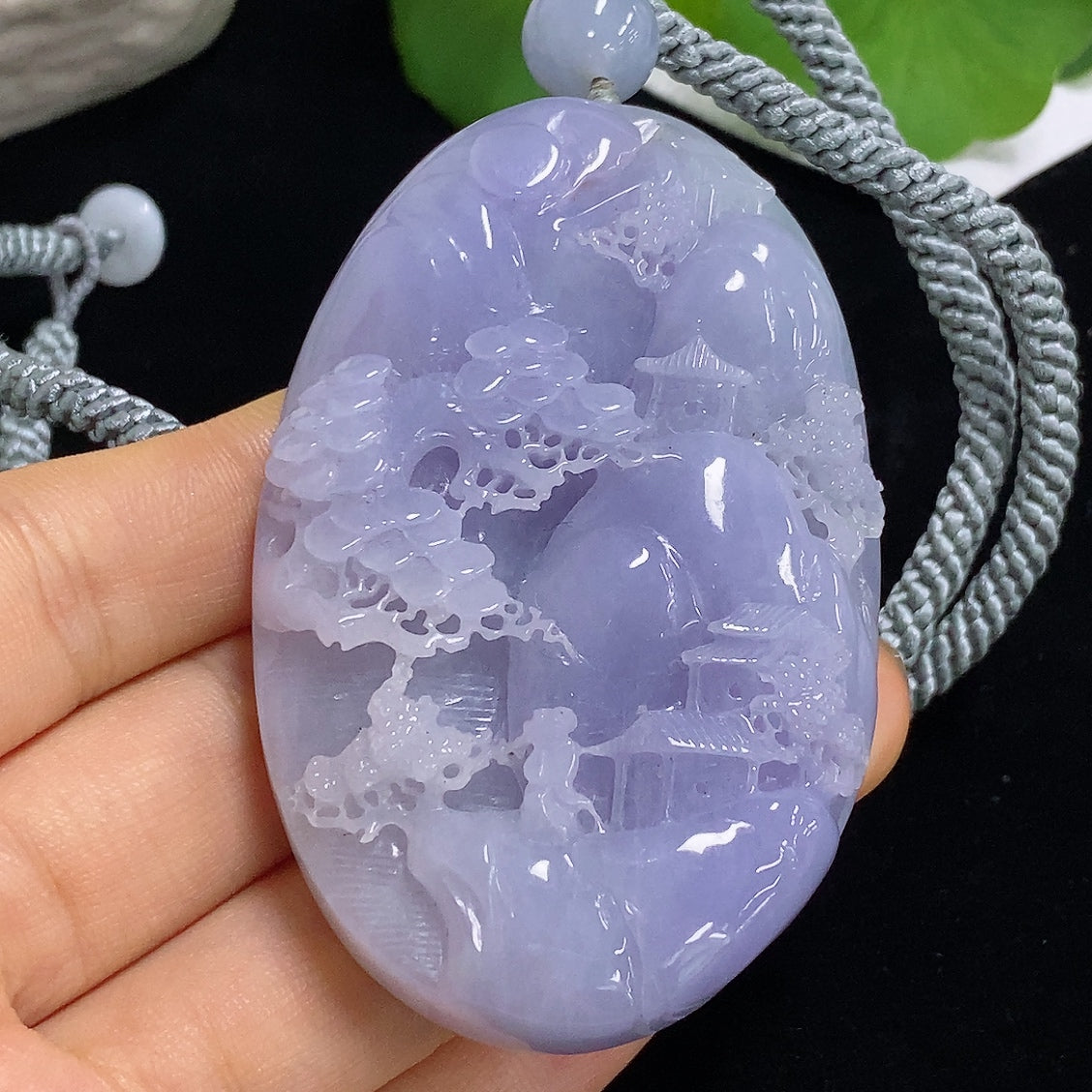 Jadeite pendant with landscape design on jade stone, HKHQ brand, includes rope, weighs approximately 110.3 grams.