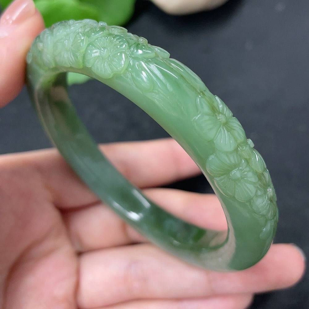 Huiliu certified Hetian jade carved flower bracelet with intricate floral details and smooth jade beads on a delicate string.