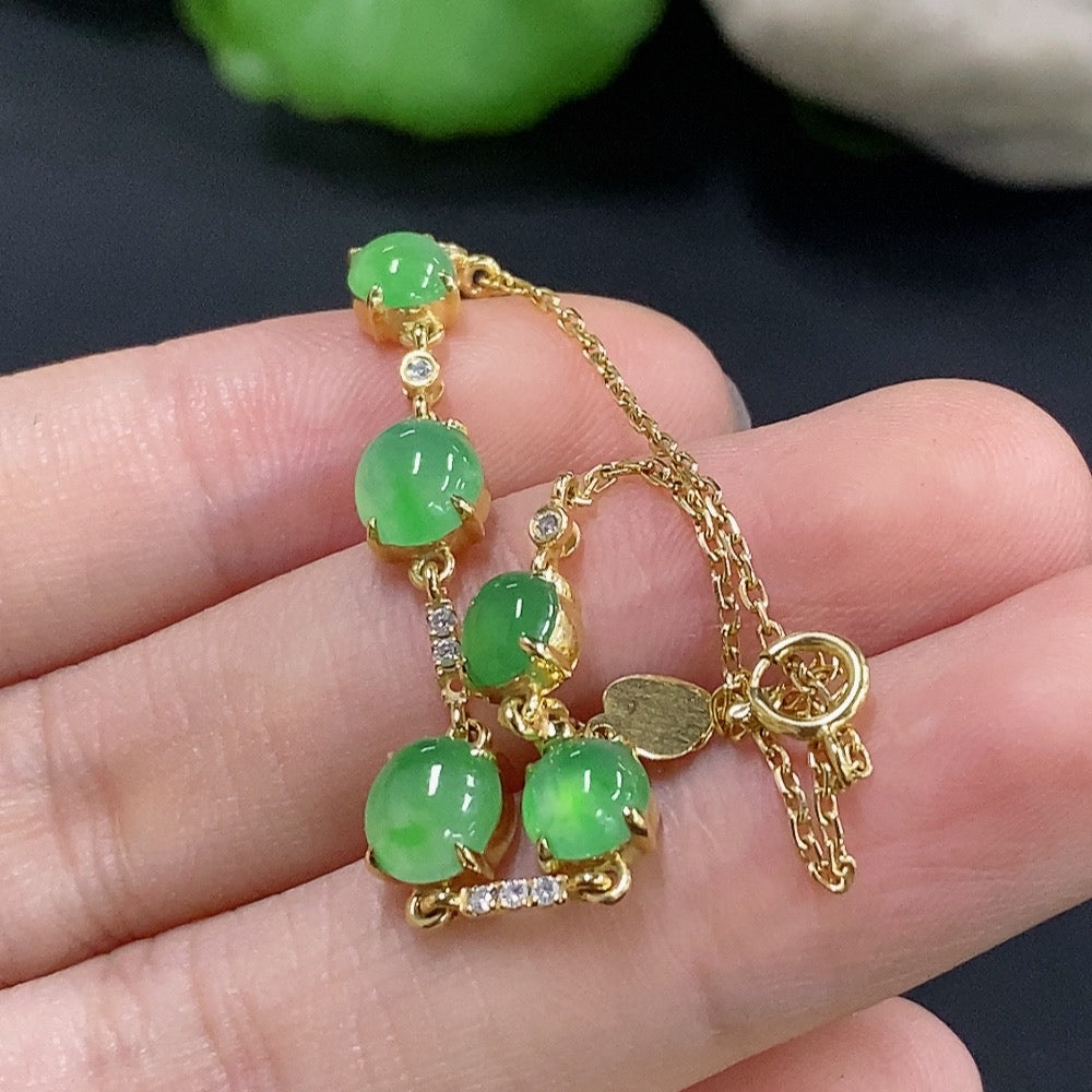 Jadeite cabochon bracelet by HKHQ with 18k gold and diamond accents, featuring smooth green jade stones and elegant design.