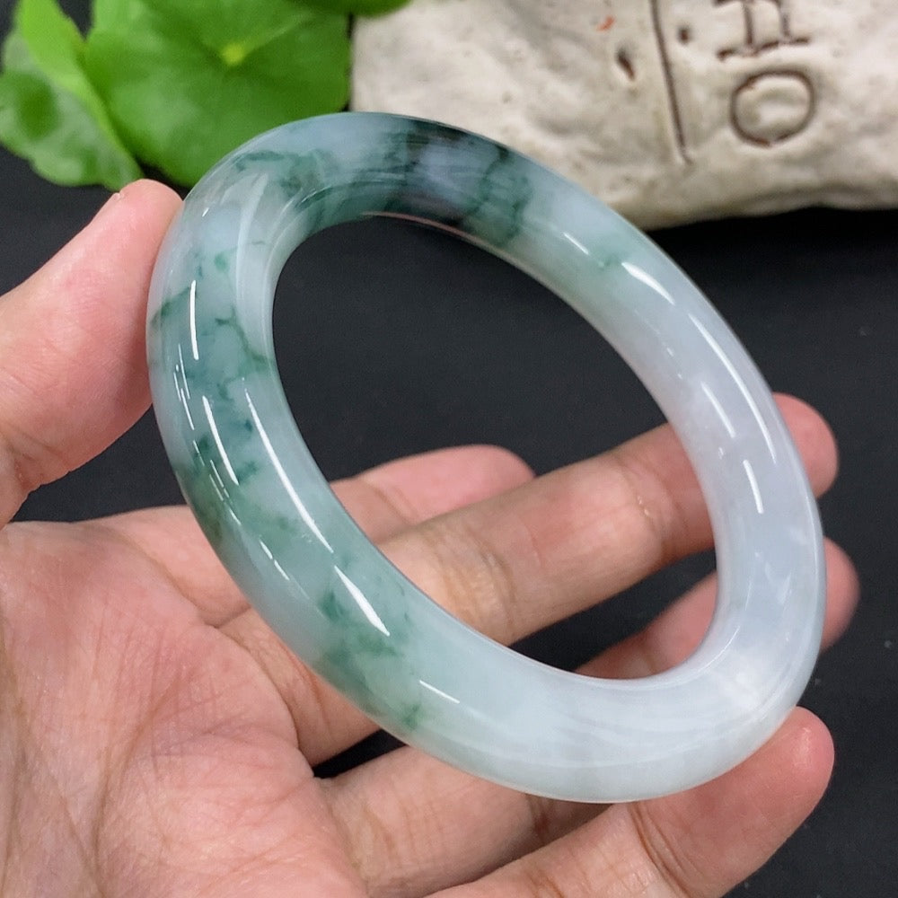 HKHQ jadeite round bangle with mineral inclusions, size 54.9, weighing approximately 65.2g, featuring smooth polished surface.