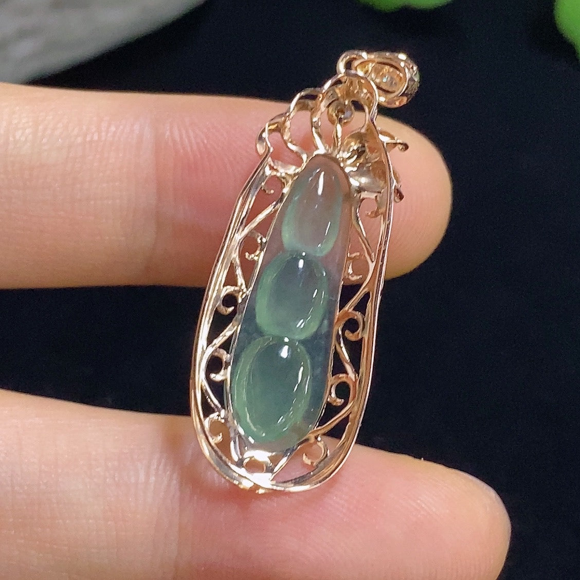 Jadeite auspicious bean pendant with 18K gold accents and diamond details, showcasing a smooth, polished jade surface.