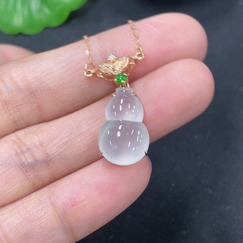 Jadeite inlaid gourd pendant with 18K gold and diamond accents, displayed on a necklace chain.