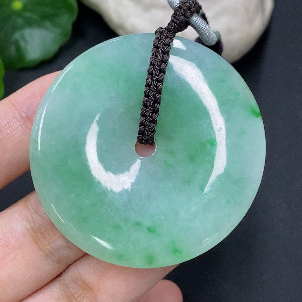 Jadeite pendant with peace knot design from HKHQ, weighs 28.34g including cord, showcasing smooth, polished jadeite craftsmanship.
